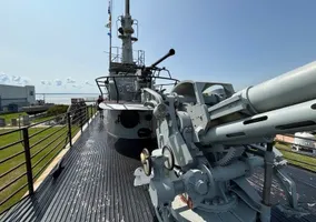 In front of the conning tower. You can sit in this AA gun and turn the cranks, it actually moves